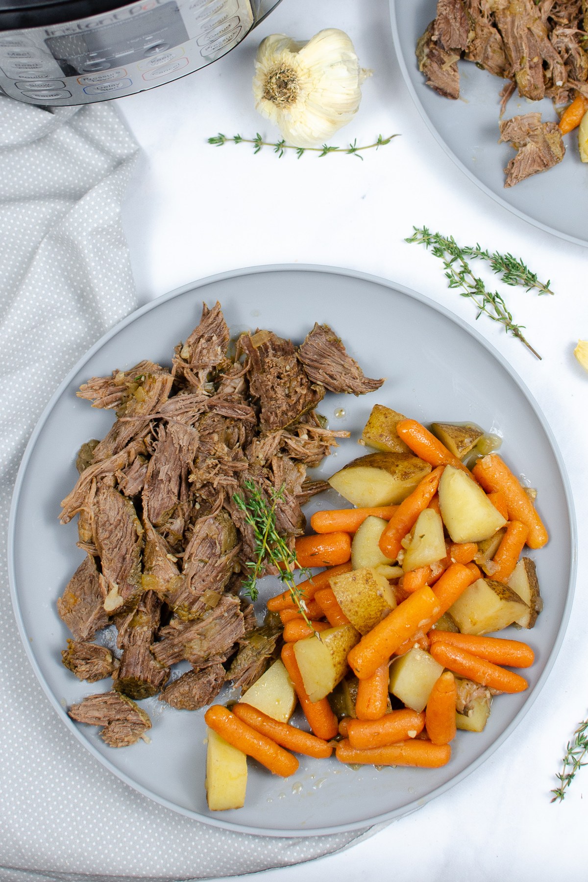 Overhead plate of shredded pot roast, carrots, and potatoes.