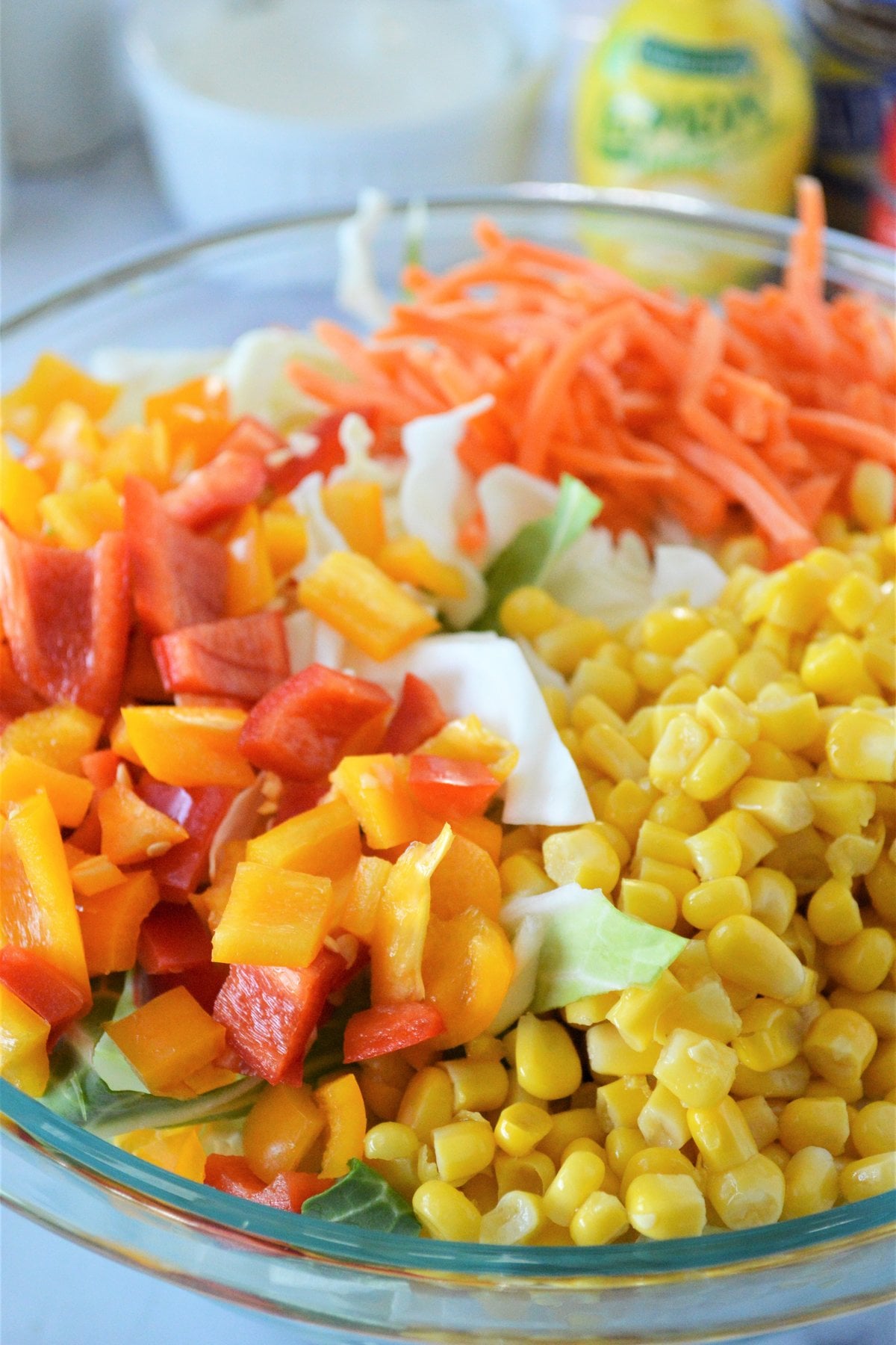 shredded carrots, chopped peppers and corn piled on sliced cabbage