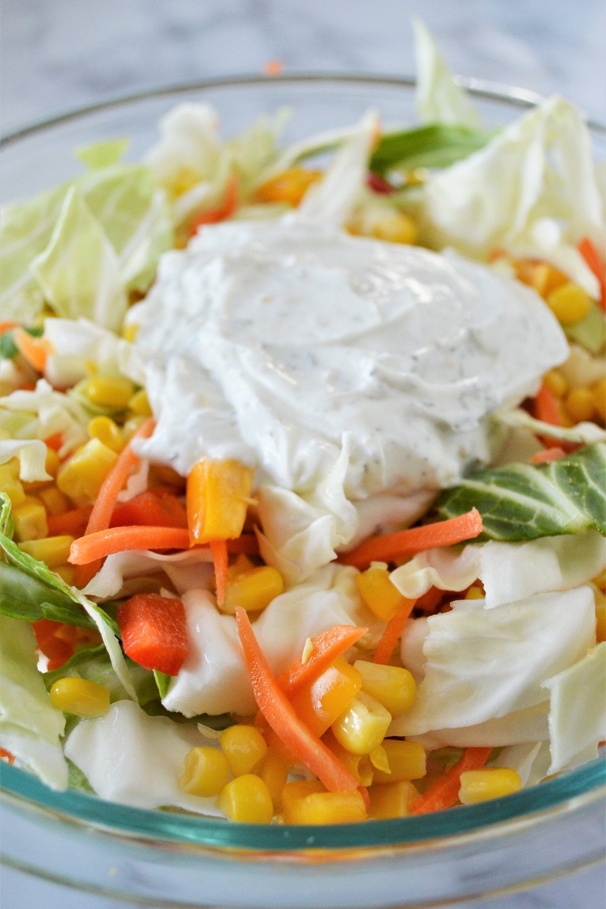 Greek yogurt dressing spooned over the coleslaw vegetables