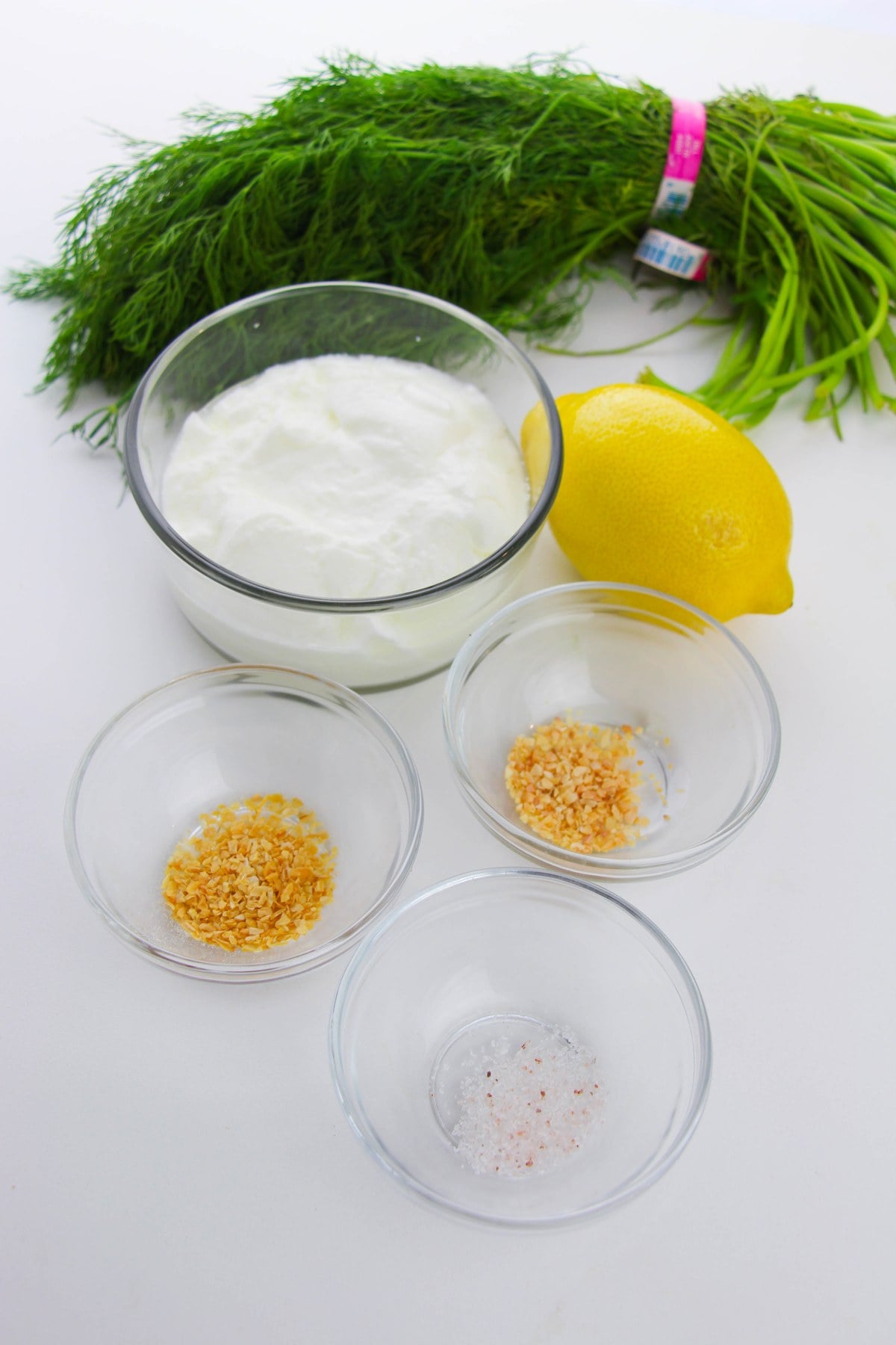 ingredients for Greek yogurt dill dip: Greek yogurt, fresh dill, lemon, dried garlic, dried onion and salt