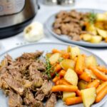 Instant Pot pot roast with carrots and potatoes served on a plate.