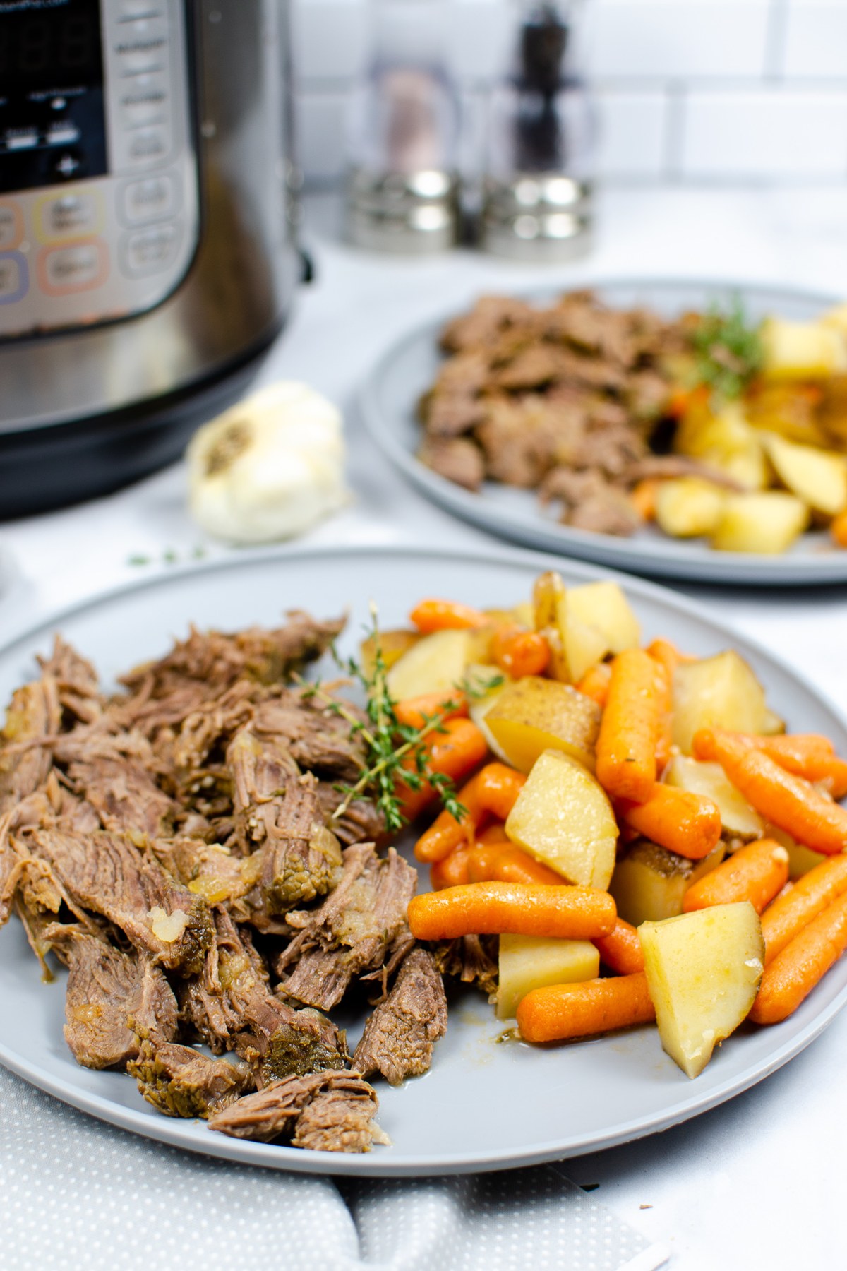 Instant Pot pot roast with carrots and potatoes served on a plate.