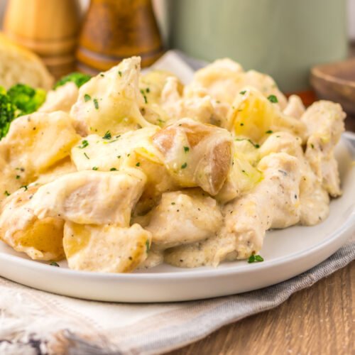 Plated cheesy Caesar chicken and potatoes.