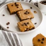 Plated no-bake date brownie squares with peanut butter caramel and chocolate chips.