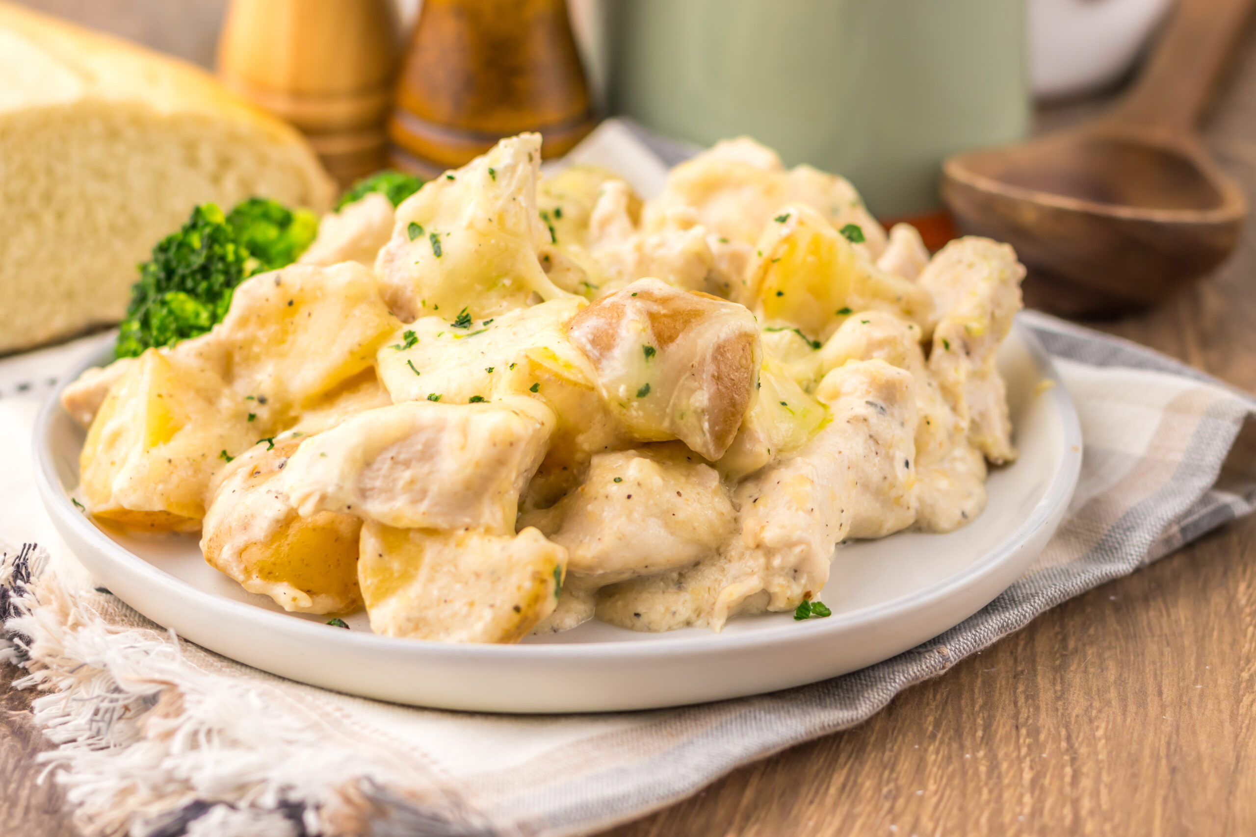 Plated cheesy Caesar chicken and potatoes.