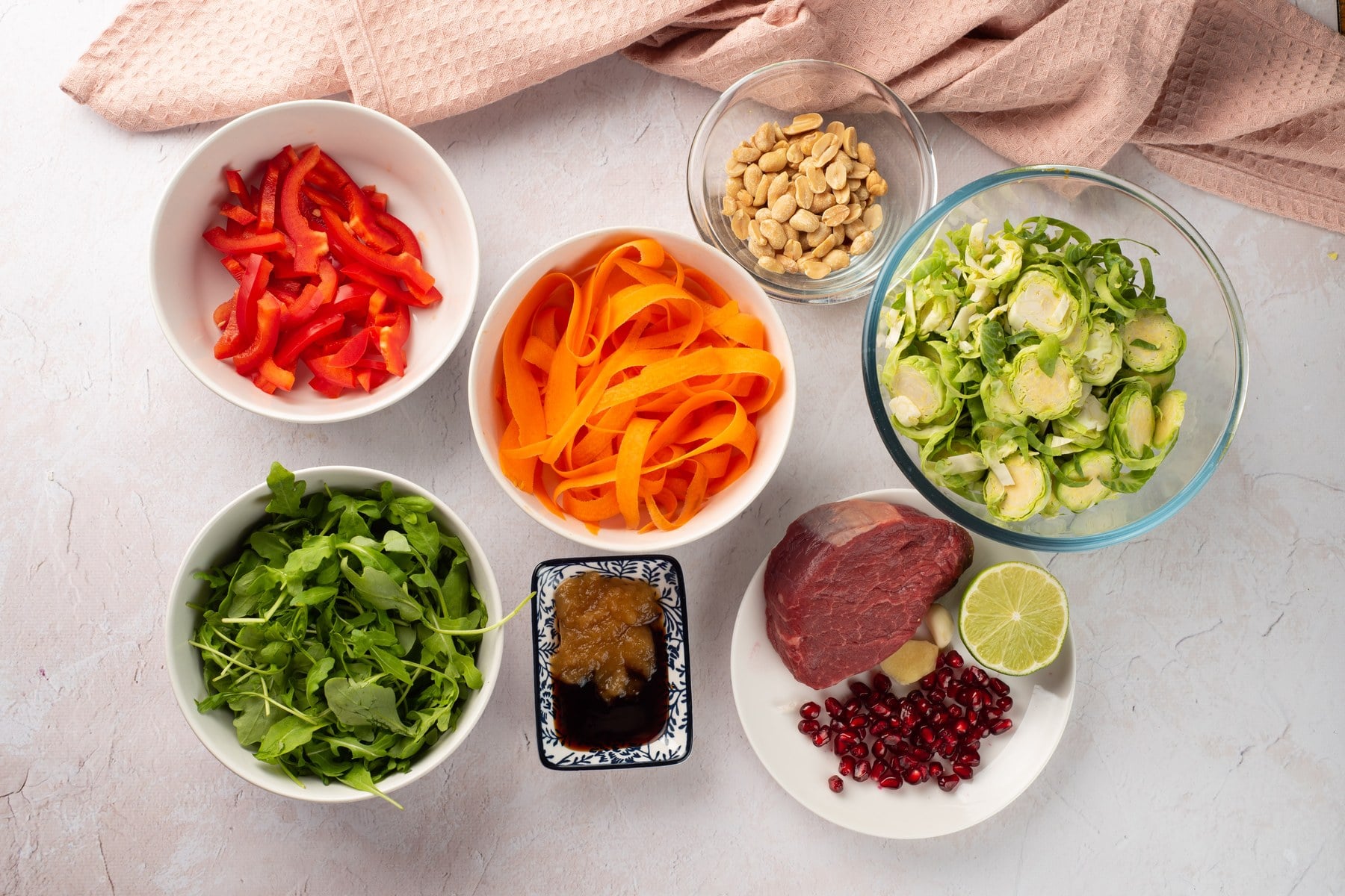 Ingredients in bowls for winter steak salad with Brussels sprouts and pomegranate.