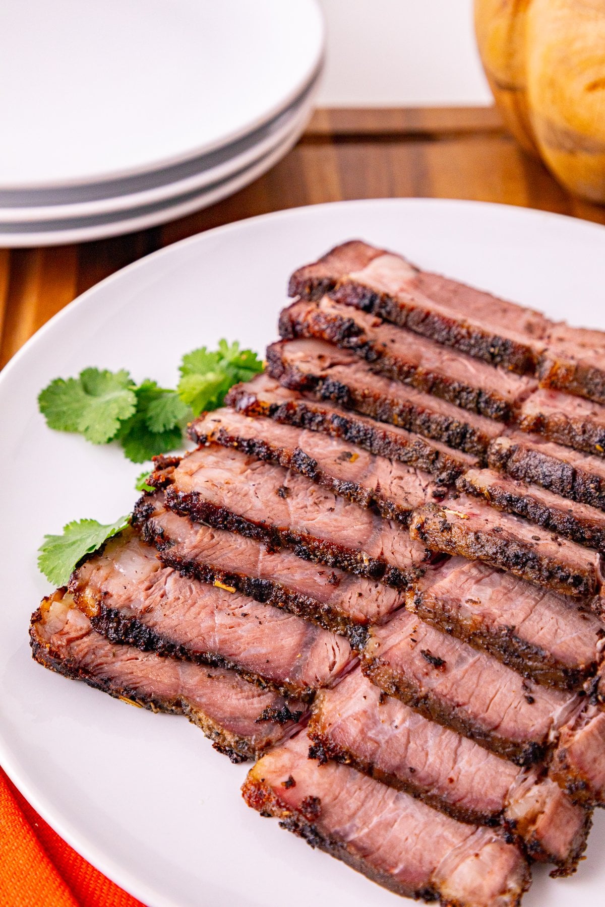 thin slices of medium chuck roast with a seasoned crust on a serving plate