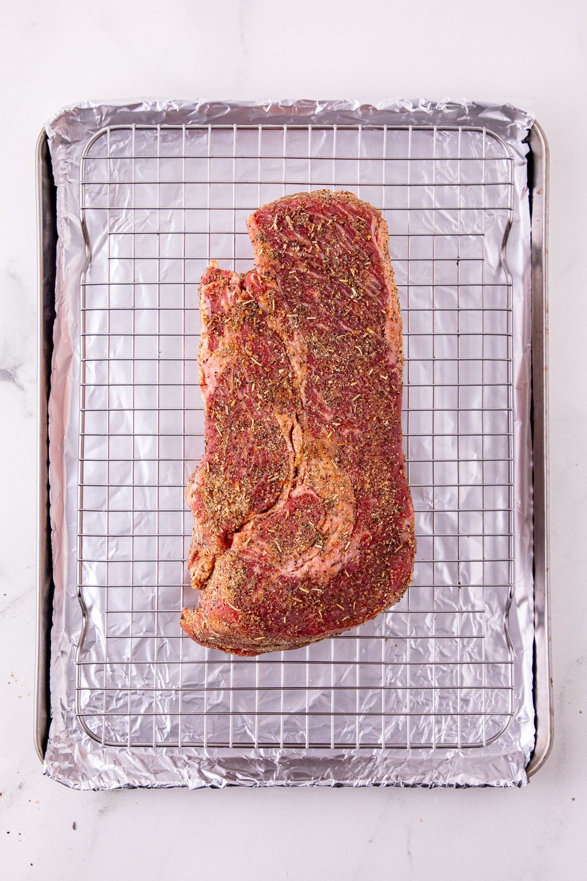 seasoned chuck roast on a wire rack over a foil-lined baking sheet