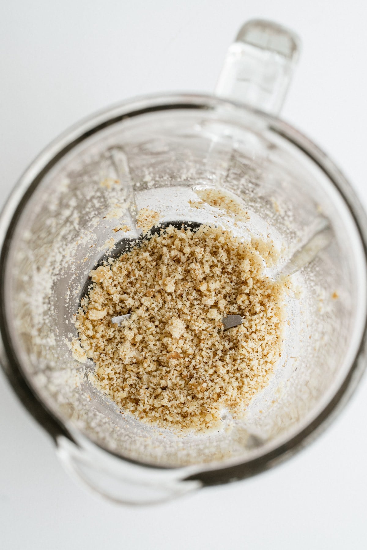 Walnuts pulsed into coarse flour in a food processor.