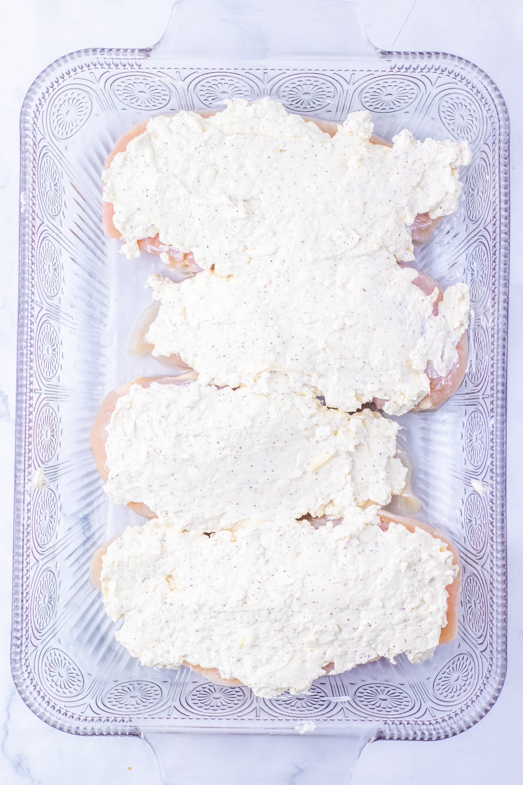 Mix the seasoned cream cheese and sour cream, then spread it over the chicken.