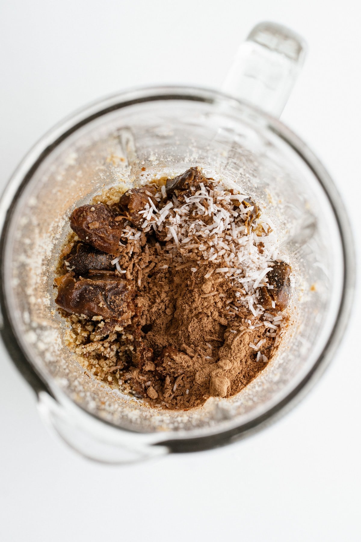 Dates, cocoa, and coconut added to the food processor.