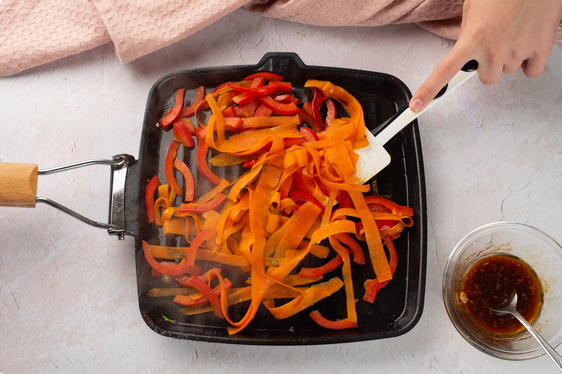 Carrot ribbons and red pepper sautéing in the skillet.