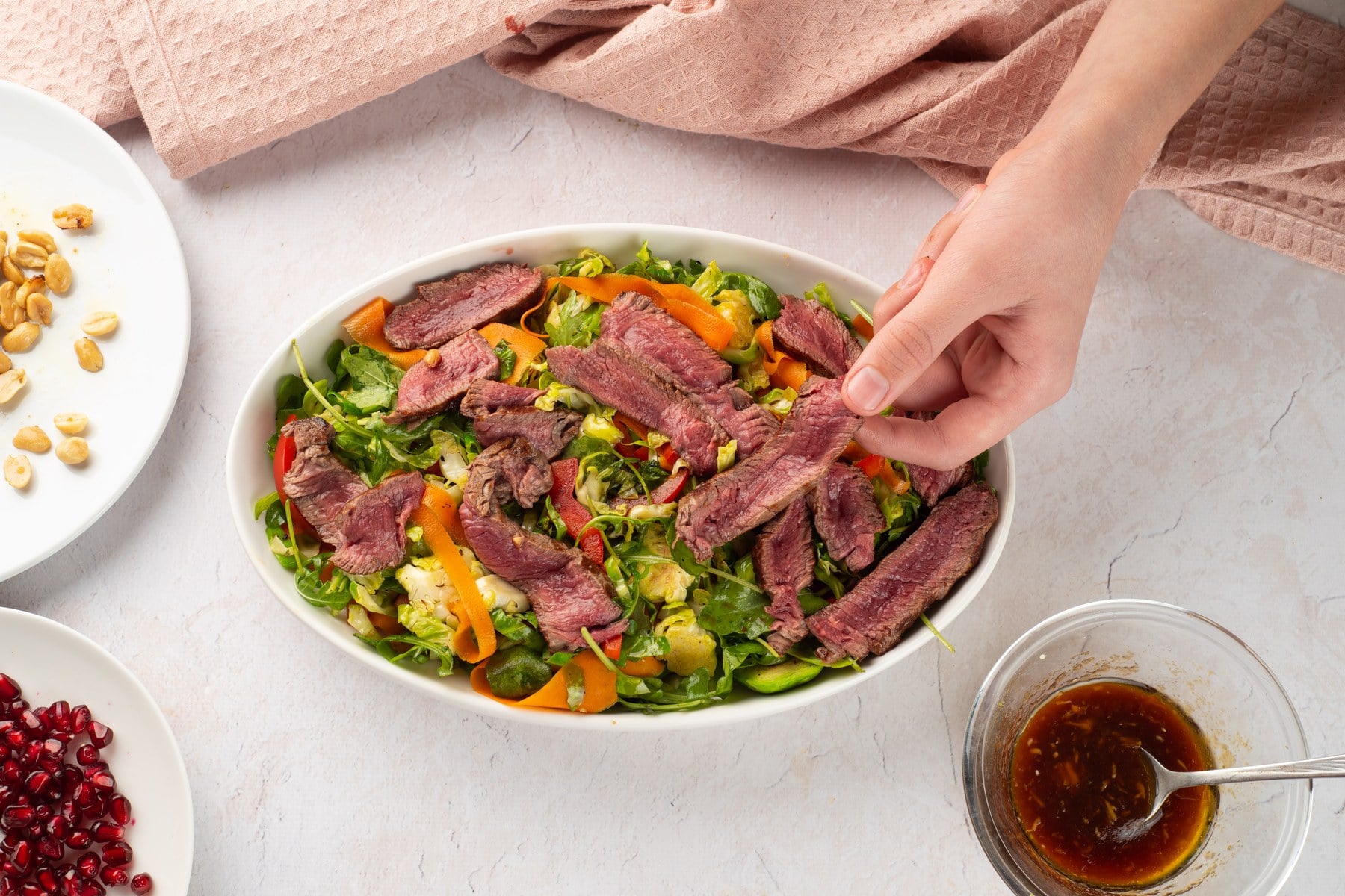 Sliced steak laid over the salad.